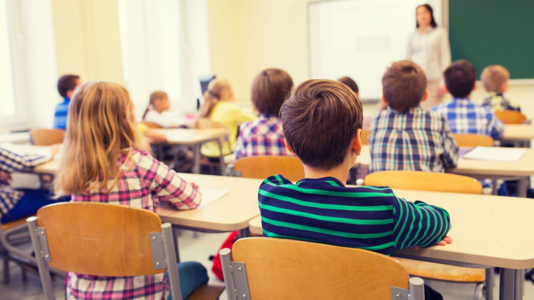 group of school kids and teacher in classroom