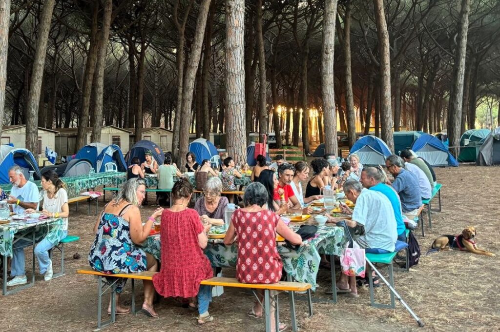 Partecipanti di Tra Terra e Cielo cenano insieme all’aperto nella pineta di Riva dei Tarquini durante le vacanze olistiche estive