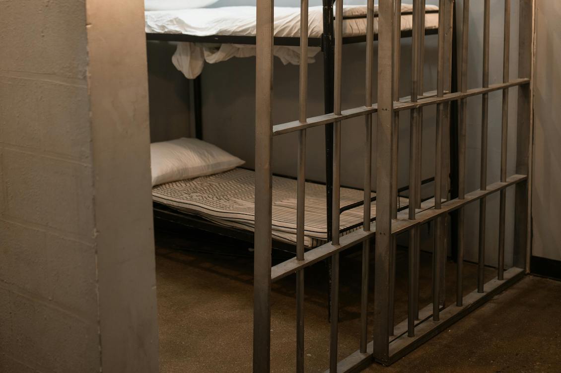 Cella carceraria vuota con letti a castello, simbolo delle condizioni che contribuiscono al record di morti in carcere