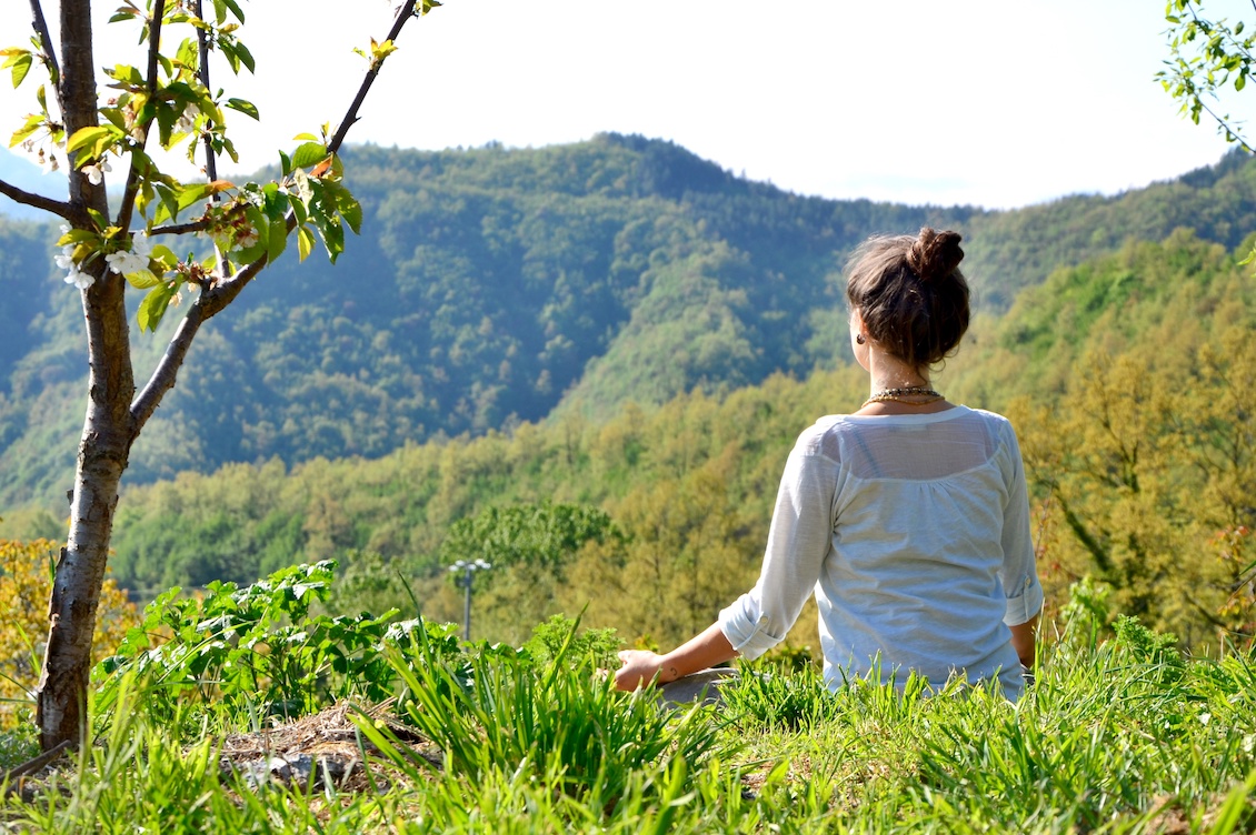 Donna in meditazione immersa nella natura durante il Ritiro nel Silenzio di Autosufficienza