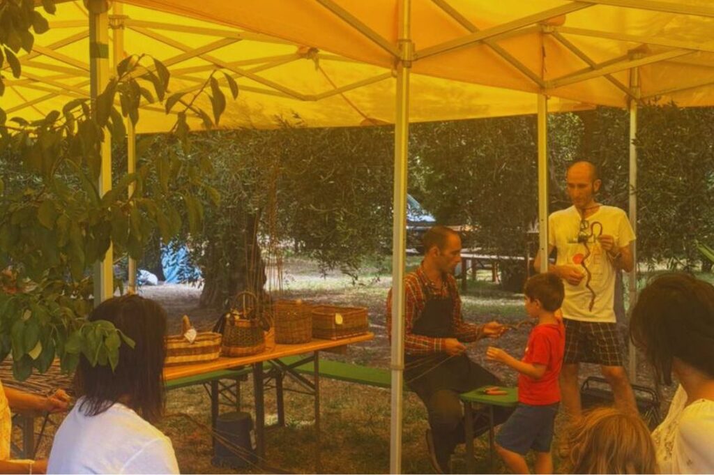 Laboratorio di intreccio con i bambini durante le vacanze olistiche Nonsolomare di Tra Terra e Cielo, attività creativa all'aperto per famiglie.