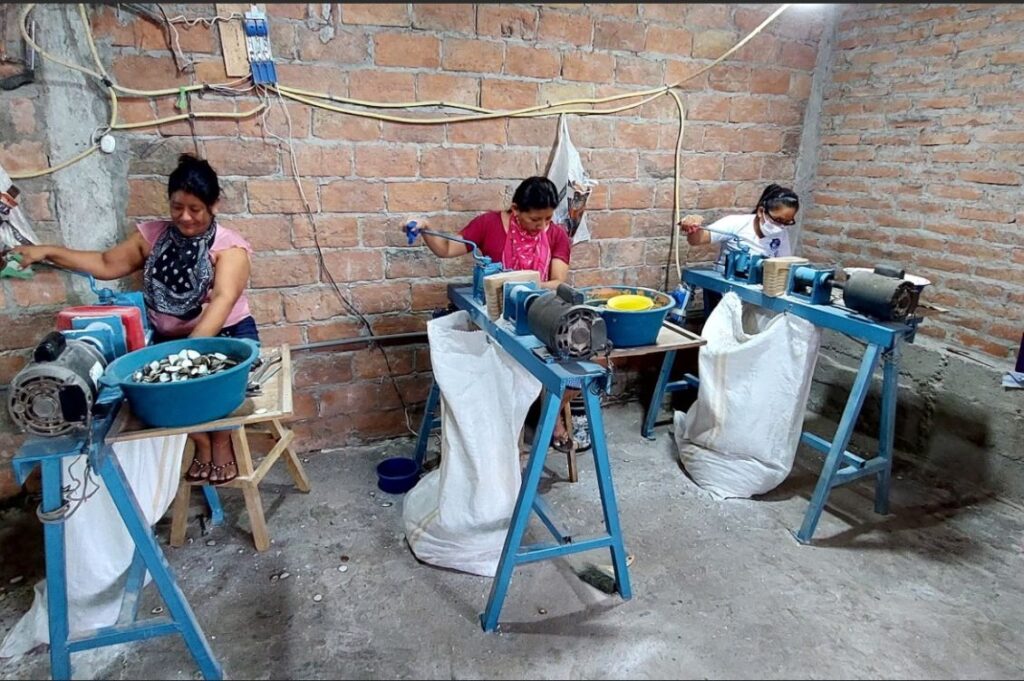 onne al lavoro in un laboratorio artigianale in Ecuador, sostenute da progetti di microcredito internazionale promossi da Banca Etica e Cresud.