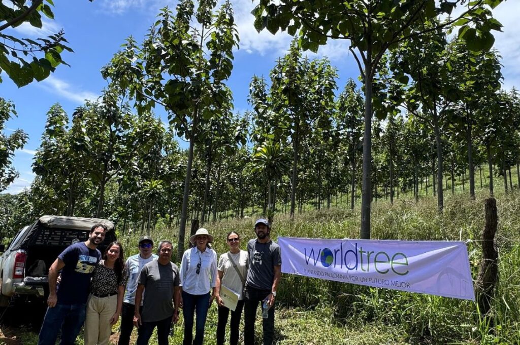 Agricoltori e staff World Tree in una piantagione di paulonia in Costa Rica, davanti a uno striscione dell’azienda.
