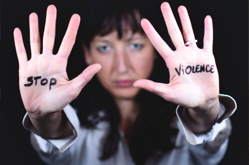Donna con le mani alzate e la scritta stop violence contro la violenza sulle donne