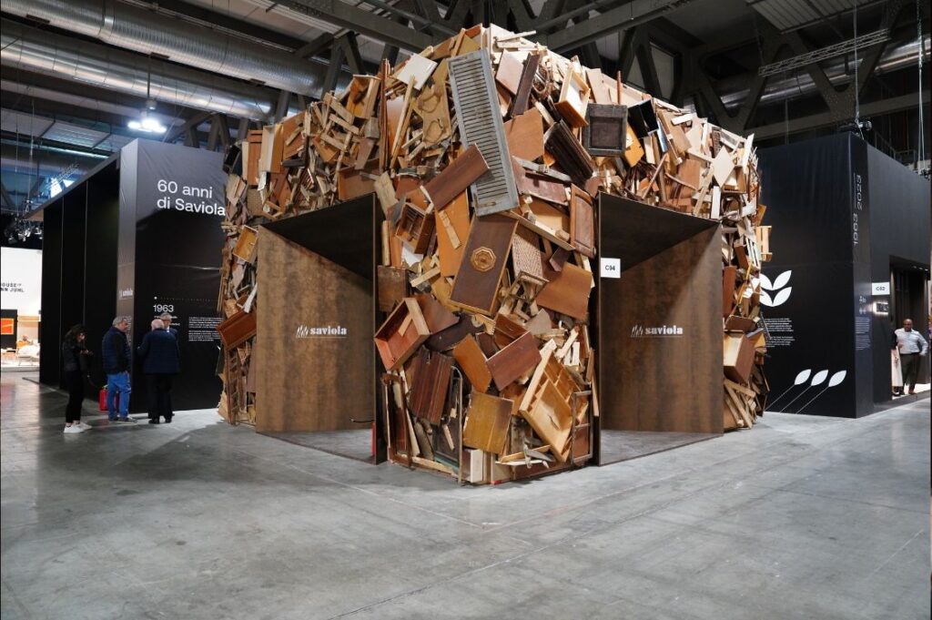 Installazione composta da mobili e pannelli in legno post-consumo che racconta la filiera circolare del legno