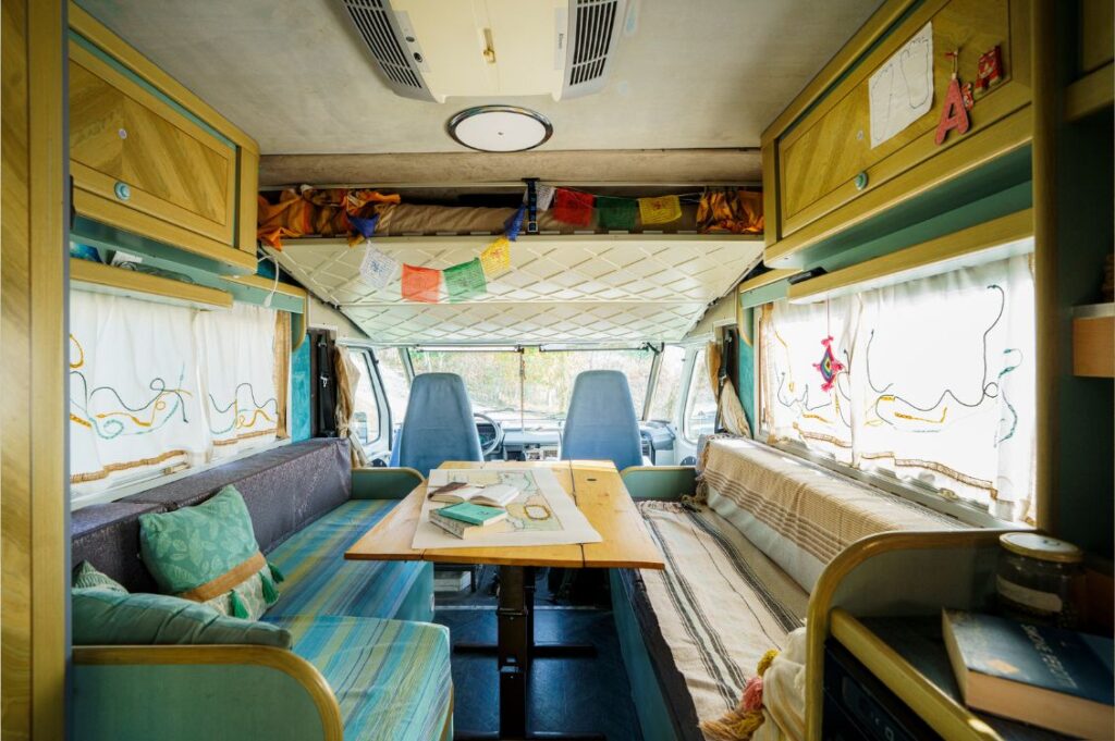 Interno del camper Libertad con tavolo e sedute, la vita a bordo nel Mediterraneo in camper