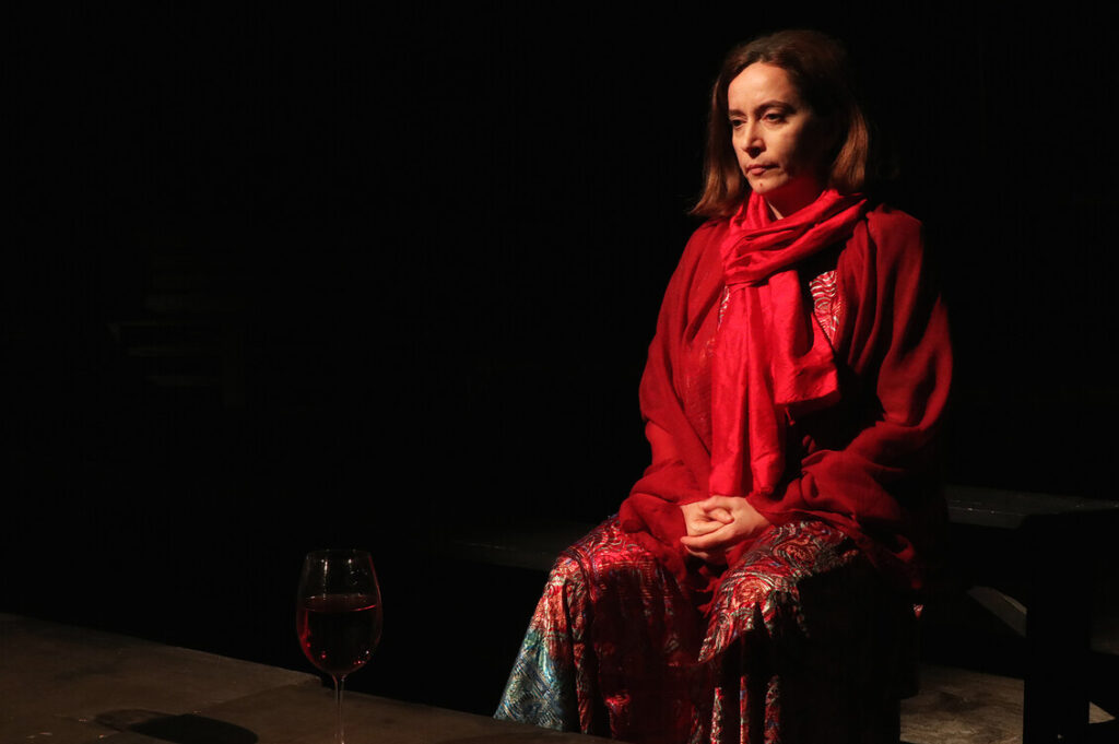 Teatro in Calabria: un’attrice in abiti rossi durante lo spettacolo Per Brecht, nel programma di EPIC Reggio.